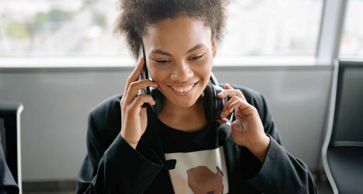 An independent recruiter focused on a call at her desk.